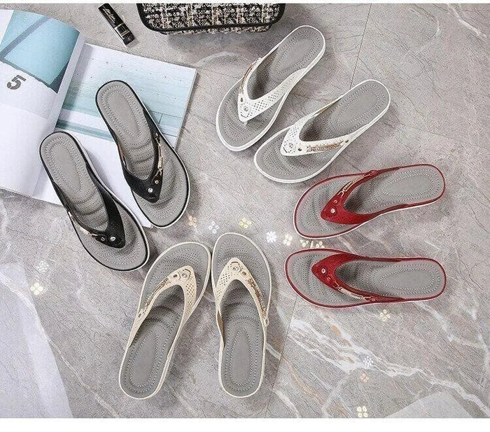 Tongs élégantes pour femmes en noir, blanc, beige et rouge, disposées sur un sol en marbre avec magazines. Mode estivale, chaussures confortables.