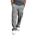 Pantalon cargo gris pour homme avec poches latérales, cordon de serrage, porté avec un t-shirt gris et des baskets blanches. Mode décontractée masculine.