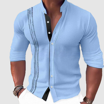 Camisa de manga larga con cuello y tapeta de botones.
