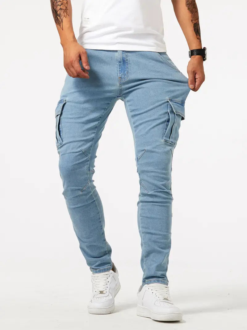Jeans cargo homme bleu clair, poches latérales, coupe ajustée, style décontracté, mode urbaine, chaussures blanches, fond blanc.