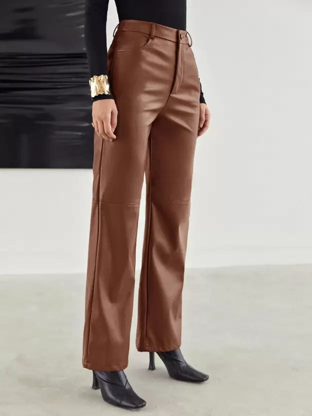 Pantalon en cuir marron pour femme, coupe droite, porté avec un haut noir et des bottines à talons. Mode élégante et tendance automne-hiver.