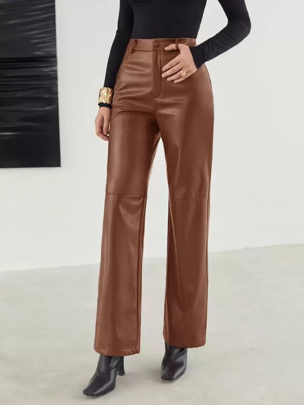 Pantalon en cuir marron pour femme, taille haute, coupe large, porté avec un haut noir à manches longues et des bottines noires, style chic et moderne.