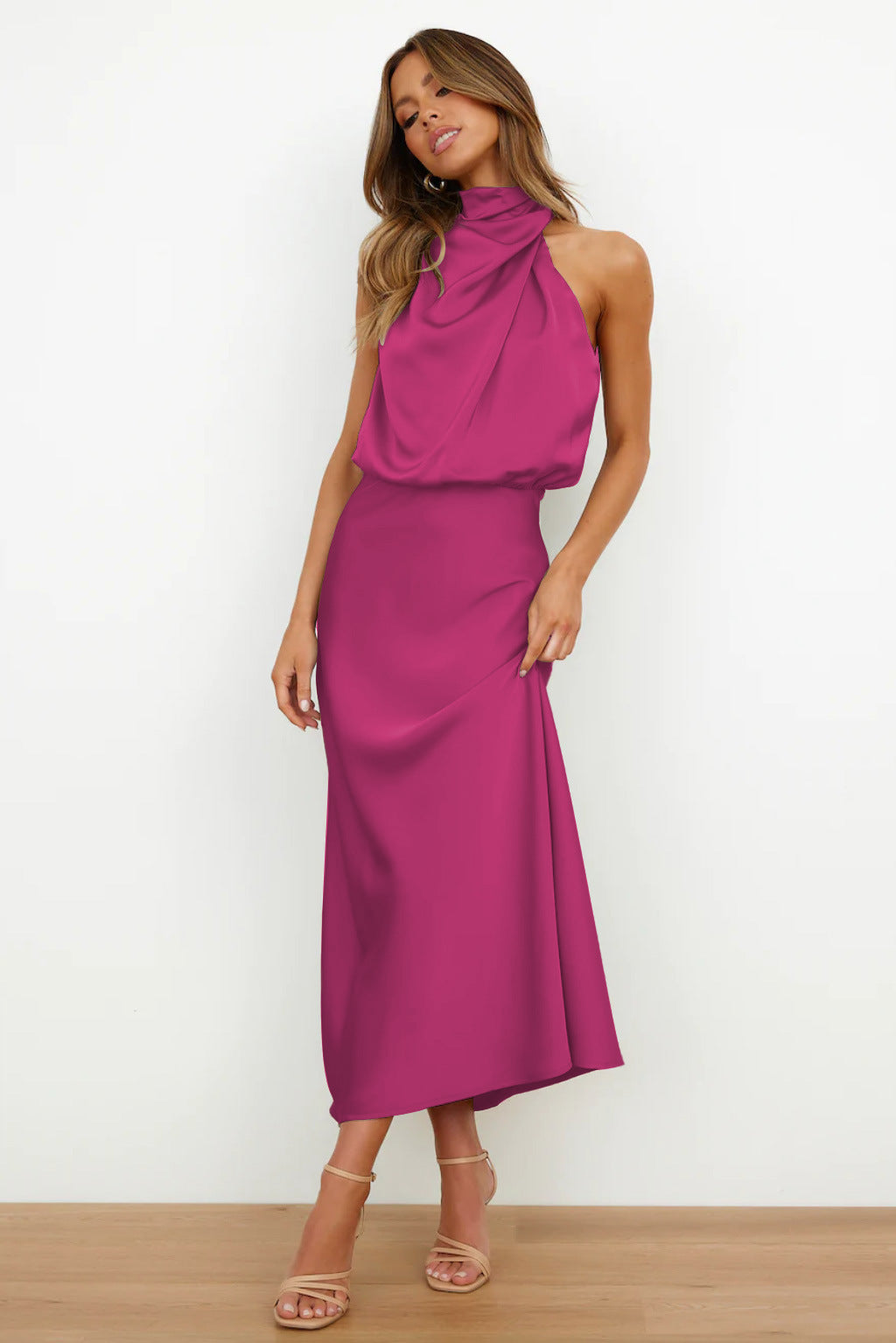 Robe longue fuchsia élégante, sans manches, col drapé, portée par une femme. Mode féminine chic, tenue de soirée tendance.