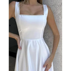 Robe blanche élégante avec décolleté carré, ornée de détails scintillants, portée par une femme. Mode féminine, tenue de soirée chic.