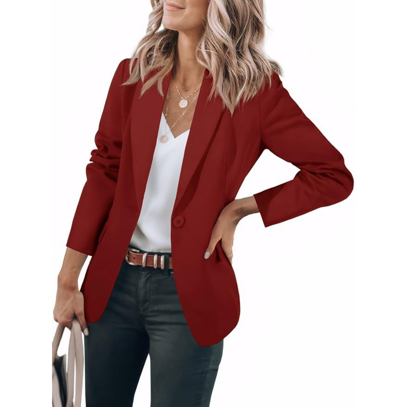 Femme portant un blazer rouge élégant, chemise blanche et jean noir, tenant un sac à main. Mode féminine chic, tenue professionnelle moderne.