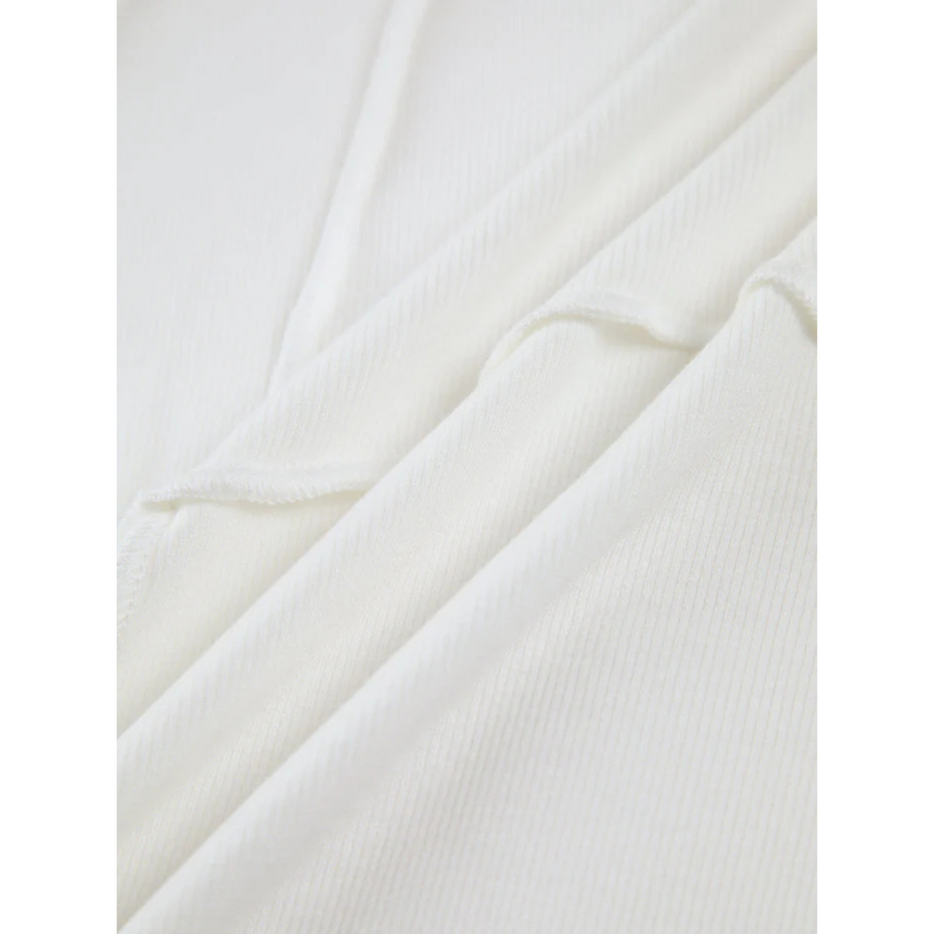 Texture de tissu blanc en coton côtelé, gros plan. Matériau doux et confortable, idéal pour vêtements et mode. Fond neutre et élégant.