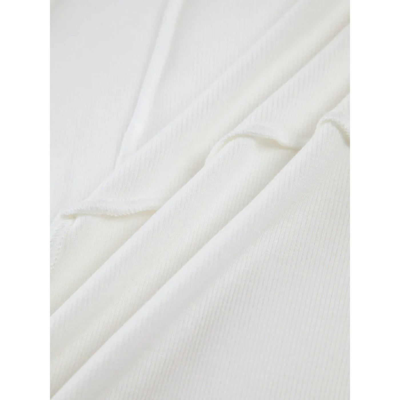 Texture de tissu blanc en coton côtelé, gros plan. Matériau doux et confortable, idéal pour vêtements et mode. Fond neutre et élégant.