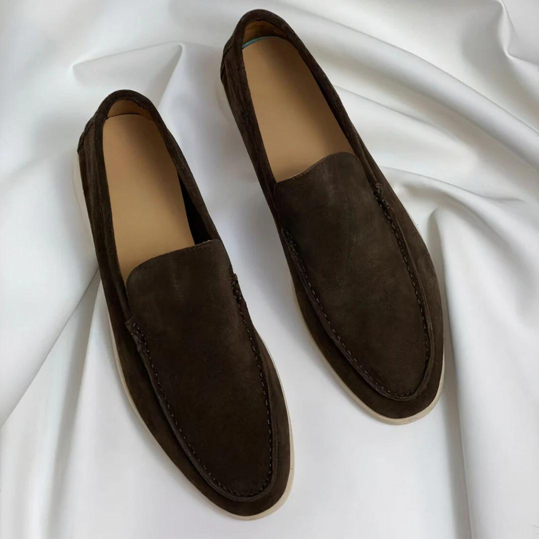 Mocassins en daim marron foncé sur fond blanc, élégants et modernes, parfaits pour un style décontracté ou formel. Chaussures homme tendance.