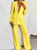 Costume femme jaune vif, blazer à un bouton et pantalon large, style élégant et moderne, mode féminine tendance, fond blanc.