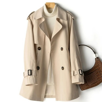 Trench-coat beige élégant sur cintre, avec pull col roulé blanc et sac à main marron texturé. Mode automne-hiver, vêtements tendance.