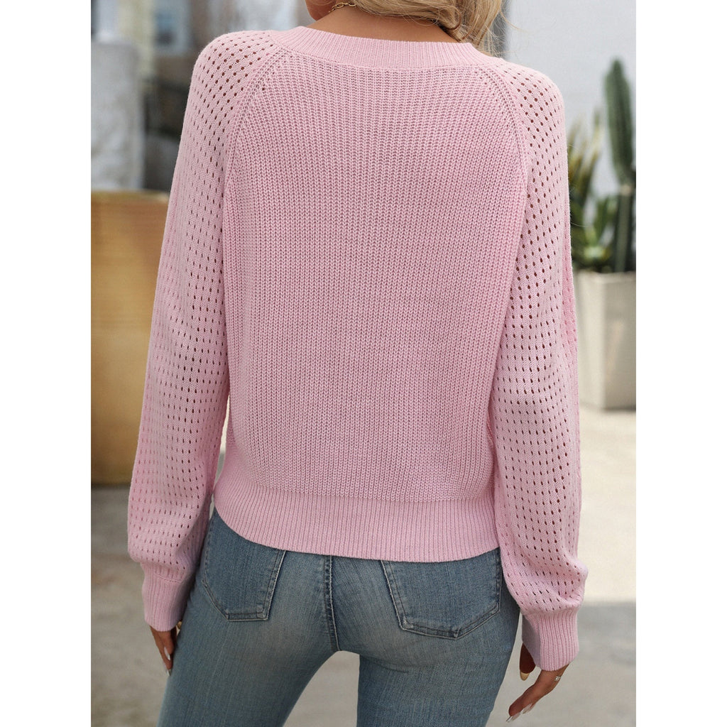 Femme portant un pull rose en maille ajourée, manches longues, dos visible, associé à un jean bleu. Mode féminine décontractée, tendance printemps.