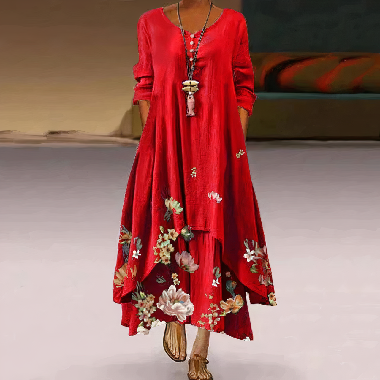 Robe rouge longue à manches longues, ornée de motifs floraux colorés, portée par une femme. Style bohème chic, mode féminine élégante.