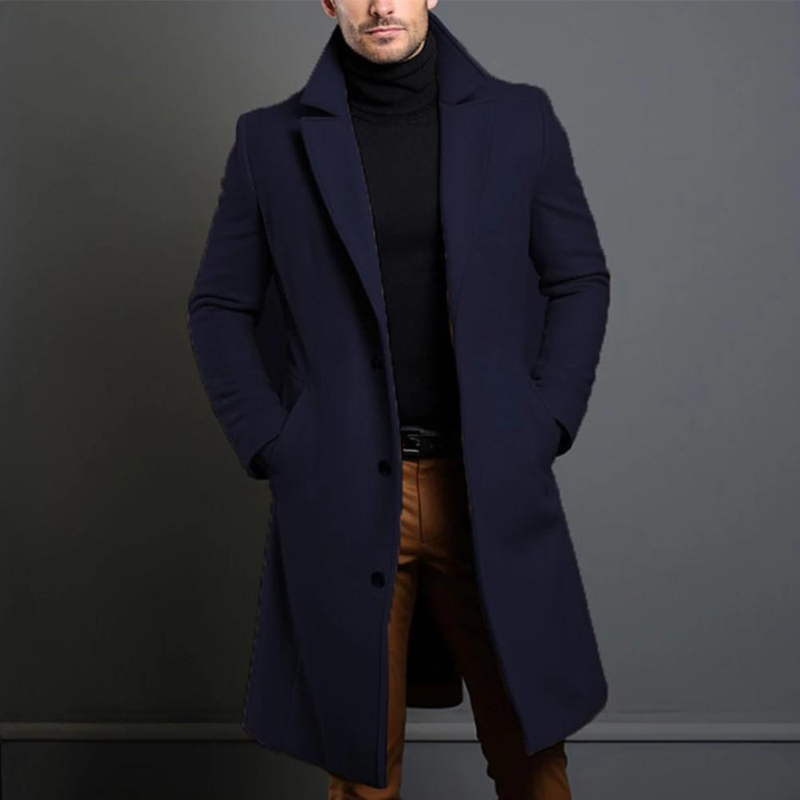 Homme portant un manteau bleu marine élégant, col relevé, sur un pull noir et un pantalon beige. Mode masculine chic et moderne.