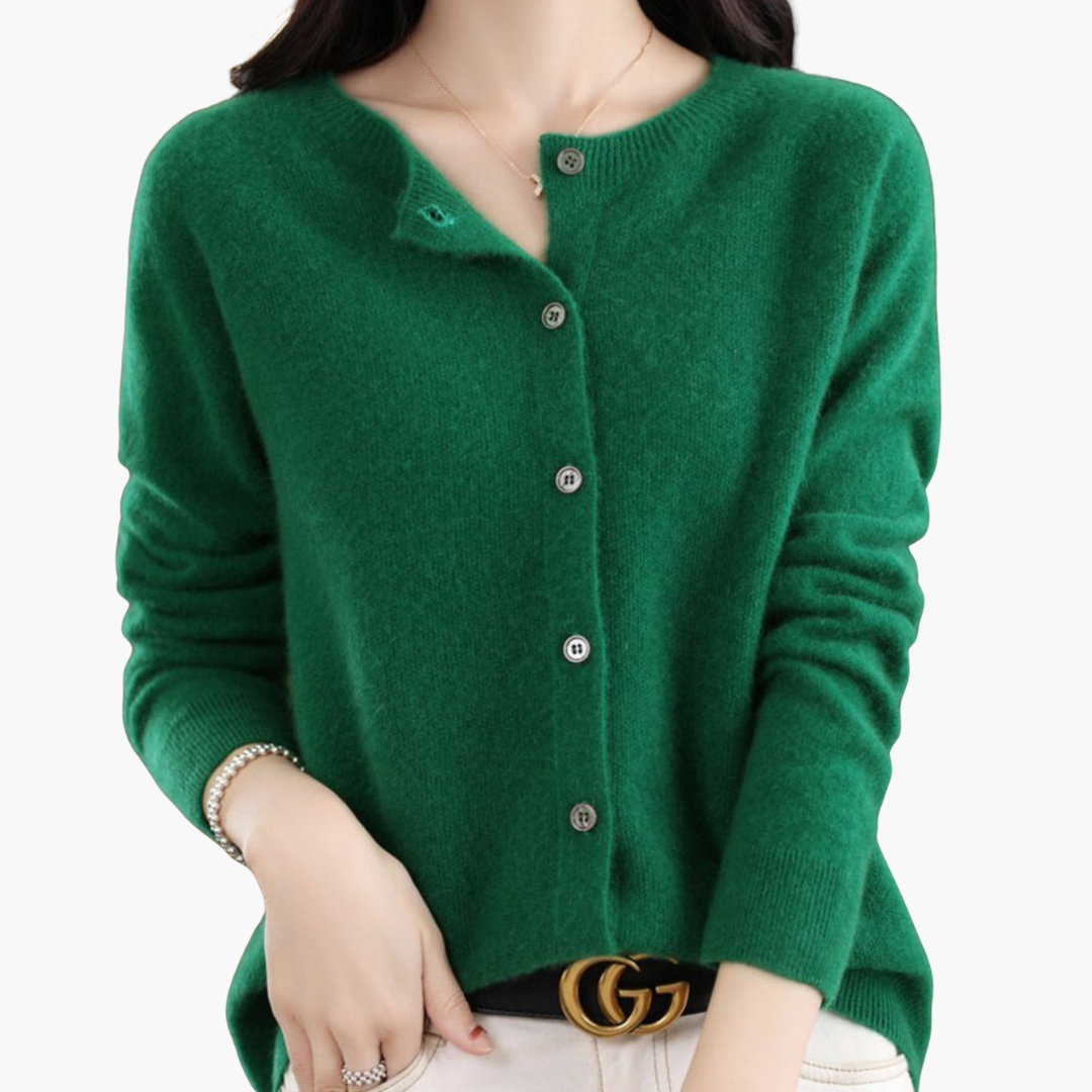 Femme portant un cardigan vert en cachemire, manches longues, boutons en métal, ceinture noire avec boucle dorée, style élégant et moderne.