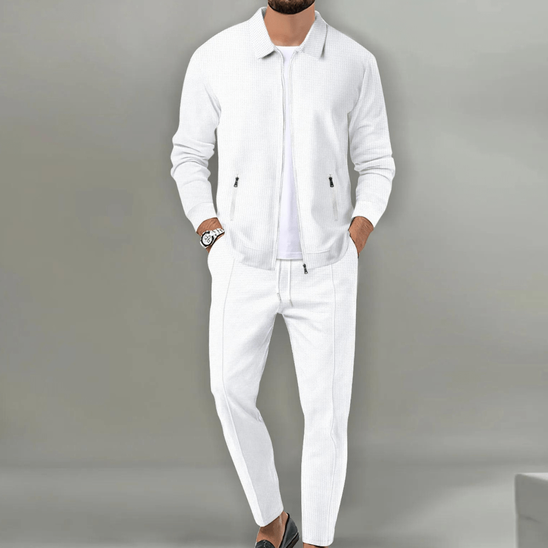 Homme en costume blanc élégant, veste et pantalon assortis, posant debout. Mode masculine, tenue chic, style moderne.