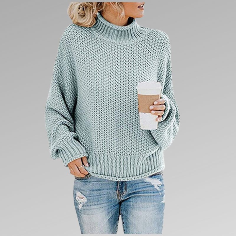 Femme en pull en maille vert clair, tenant un gobelet de café, portant un jean déchiré. Mode décontractée, style automne-hiver, look tendance.