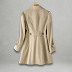 Trench-coat beige élégant pour femme, vu de dos, avec ceinture et boutons décoratifs, suspendu sur un cintre. Mode automne, vêtement chic.