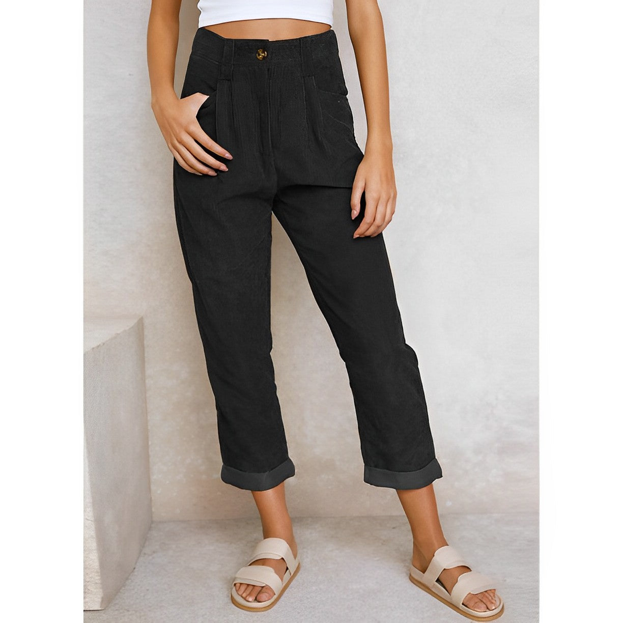 Pantalon noir femme taille haute, coupe ample, poches latérales, ourlets retroussés, style décontracté, mode tendance, fond neutre.