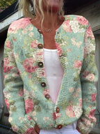 Femme portant un cardigan en tricot à motifs floraux roses et verts, boutons en bois, sur un débardeur blanc. Mode vintage, style bohème chic.