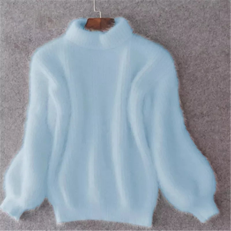 Pull bleu ciel en laine moelleuse, manches bouffantes, col montant, suspendu sur un cintre en bois, fond gris. Mode hiver, vêtement chaud.