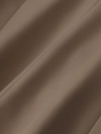 Tissu marron en gros plan, texture douce et plissée, textile élégant pour mode et décoration intérieure, fond neutre et chaleureux.