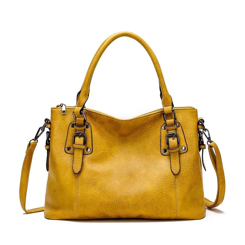 Sac à main en cuir jaune avec bandoulière amovible, détails métalliques et fermetures éclair. Accessoire mode élégant pour femme.
