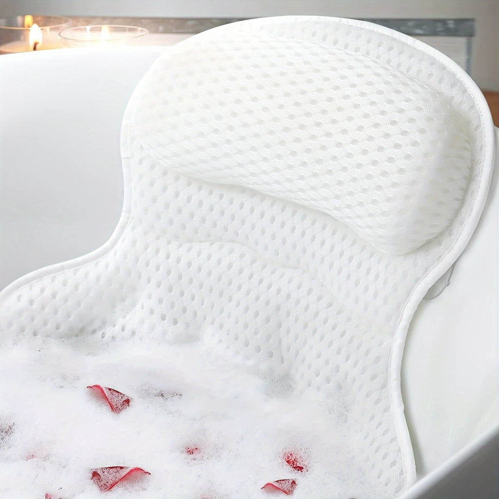 Coussin de bain blanc ergonomique en mousse, posé dans une baignoire remplie de mousse et de pétales de rose, idéal pour le confort et la relaxation.