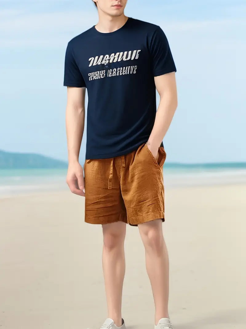 Homme en t-shirt bleu marine avec texte blanc et short marron sur une plage ensoleillée. Mode estivale, tenue décontractée, bord de mer.