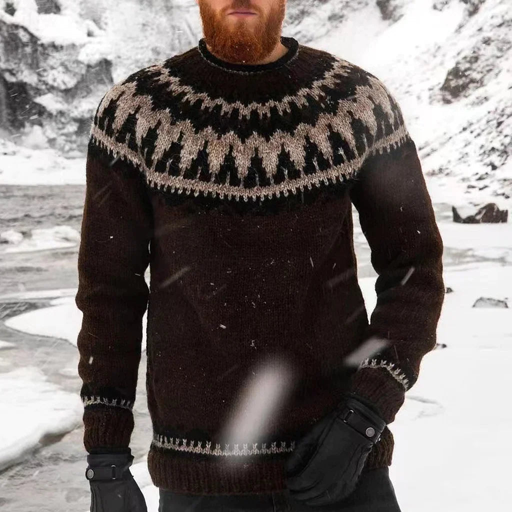Homme portant un pull en laine islandais marron avec motifs traditionnels, debout dans un paysage enneigé. Mode hiver, vêtements chauds.