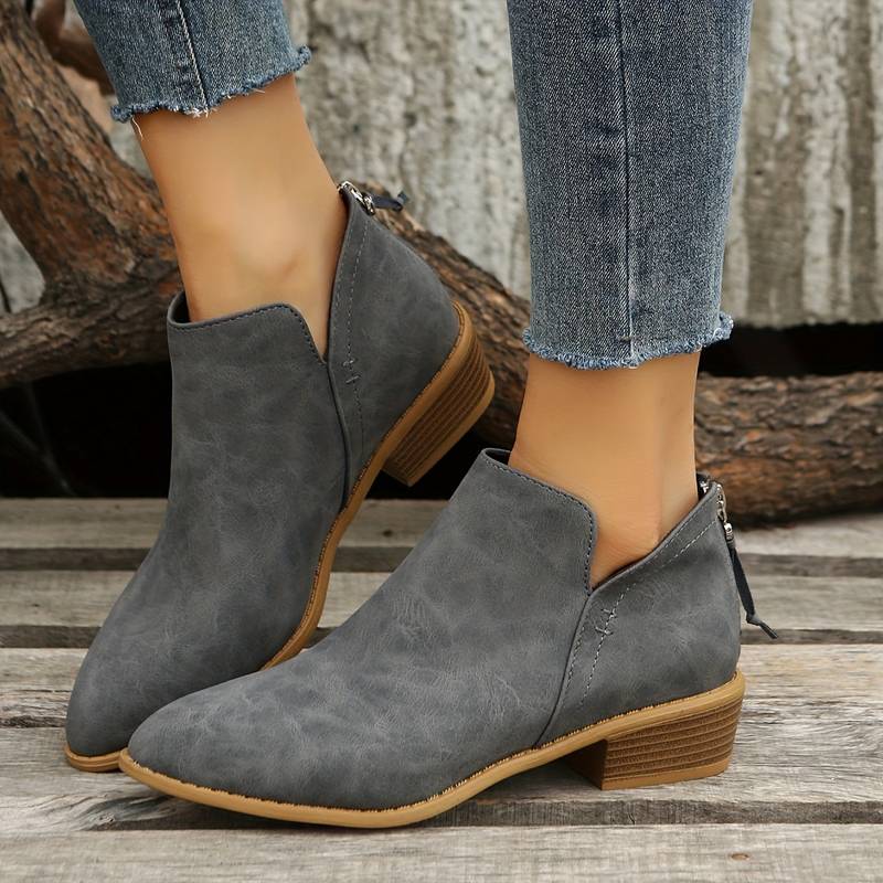Bottines en cuir gris pour femme, talon bas, style décontracté, portées avec un jean. Chaussures tendance automne, confort et élégance.