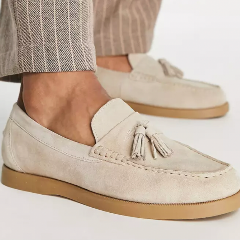 Mocassins en daim beige avec pampilles, semelle en caoutchouc, portés avec un pantalon à rayures. Chaussures élégantes pour homme.