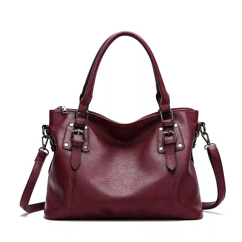 Sac à main en cuir bordeaux élégant avec anses robustes et bandoulière amovible, idéal pour la mode féminine et le style chic.
