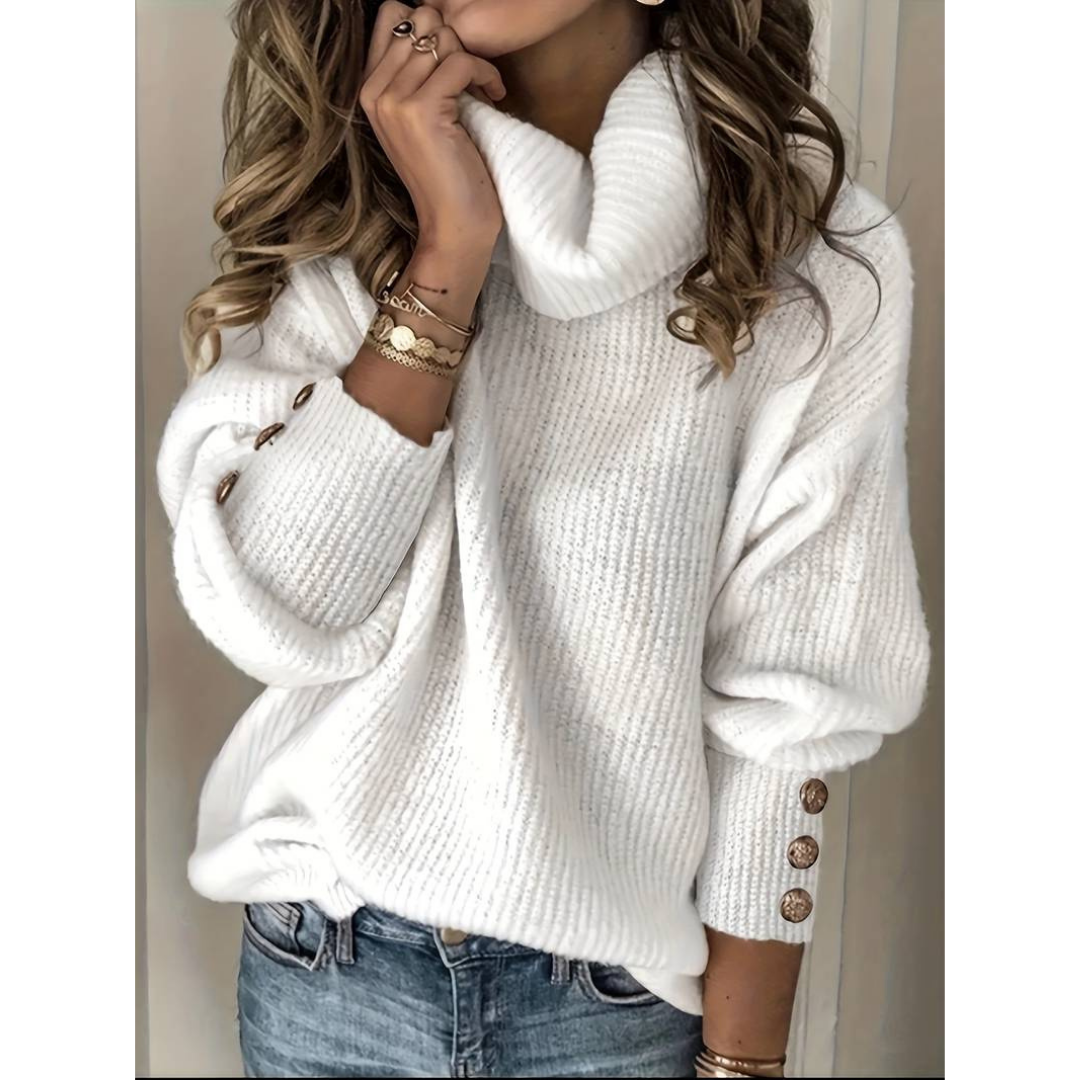 Femme portant un pull blanc à col roulé, manches longues avec boutons dorés, associée à un jean bleu. Mode automne-hiver, style décontracté chic.