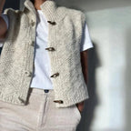 Gilet en laine beige avec boutons en bois, porté sur un t-shirt blanc. Mode automne-hiver, style décontracté et élégant, tendance vêtements en laine.