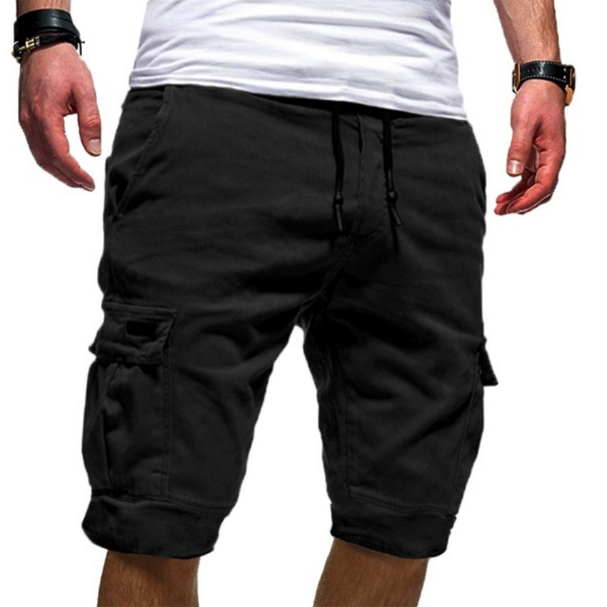 Homme portant un short cargo noir, style décontracté, avec poches latérales, cordon de serrage, idéal pour l'été et les activités en plein air.