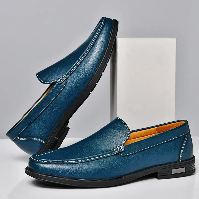 Mocassins en cuir bleu pour homme, élégants et modernes, avec semelle noire antidérapante. Chaussures décontractées idéales pour un style chic.