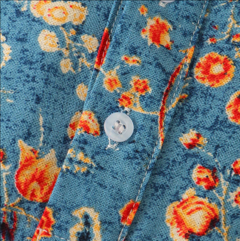 Chemise en tissu bleu à motifs floraux orange et jaunes, bouton blanc. Mode, vêtements imprimés, style floral, tendance textile.