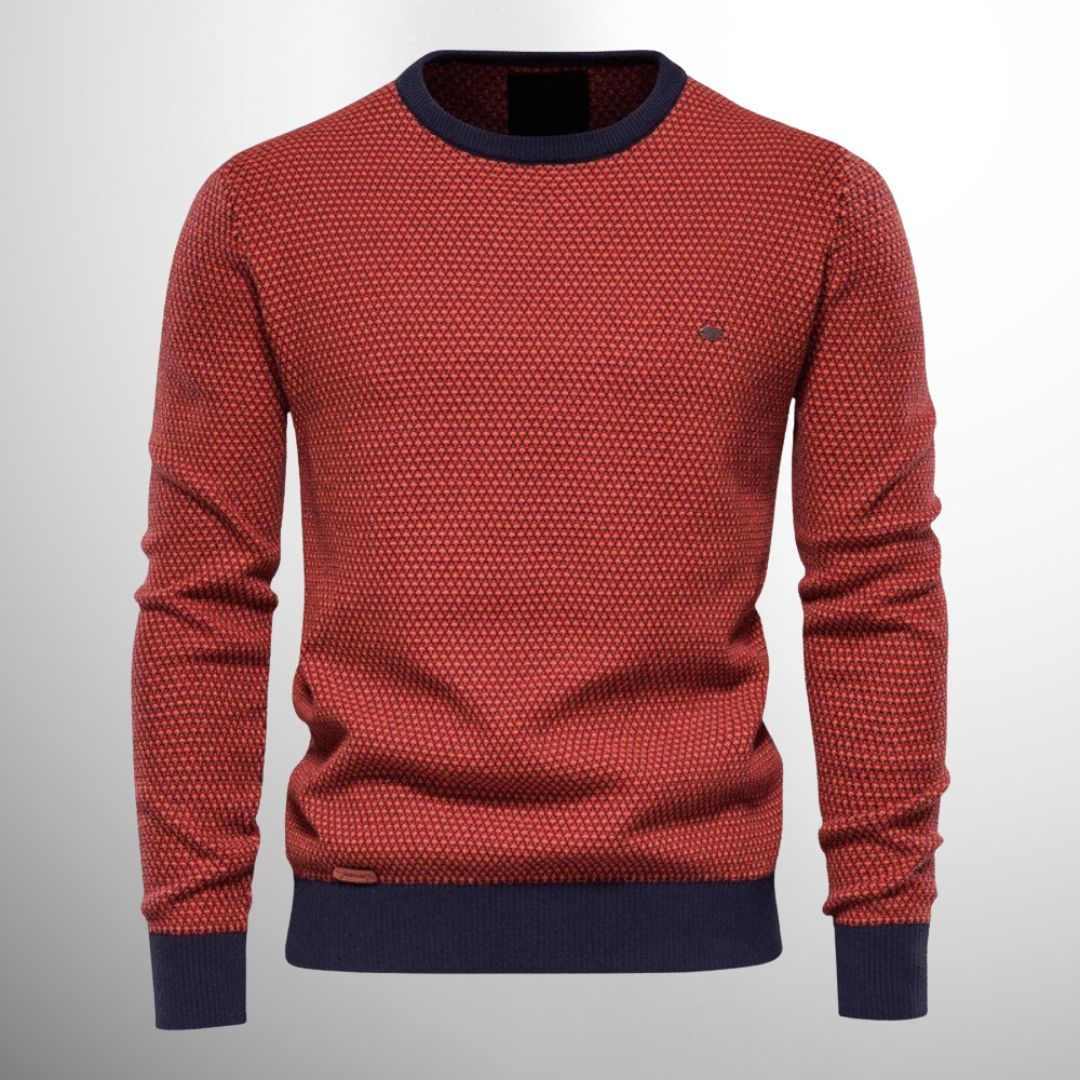 Pull-over rouge à motifs géométriques, col rond et manches longues, bordures bleu marine. Mode homme, style décontracté, tendance automne-hiver.