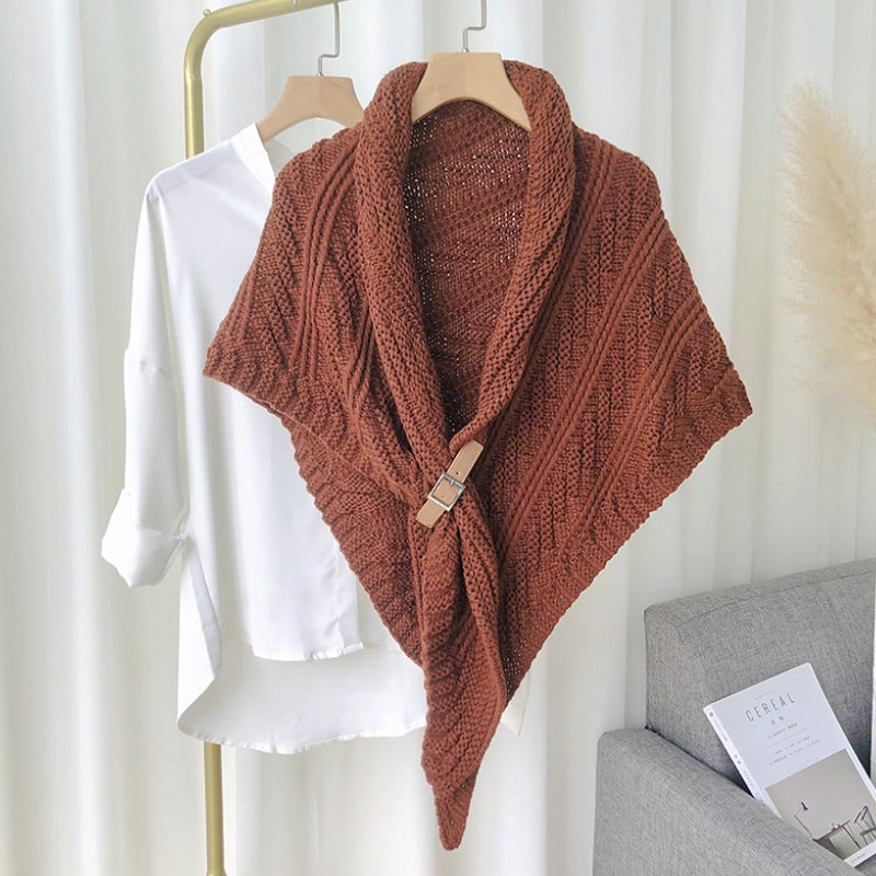 Châle en tricot marron suspendu sur chemise blanche, style élégant et moderne, décoration intérieure minimaliste, mode automne-hiver.