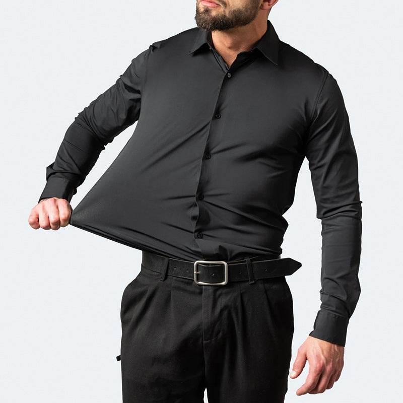 Homme portant une chemise noire ajustée, manches longues, avec un pantalon noir et une ceinture. Mode masculine élégante et moderne.