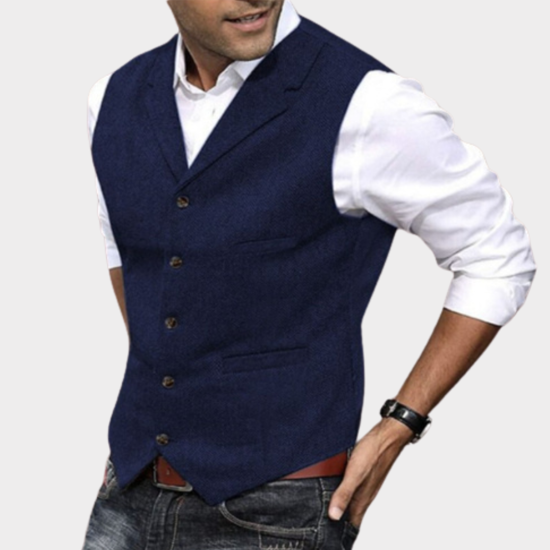 Homme portant un gilet bleu marine élégant sur chemise blanche, style décontracté chic, mode masculine, tenue moderne, montre noire, jean.