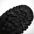 Semelle de chaussure de randonnée noire avec crampons robustes, offrant adhérence et durabilité. Idéale pour terrains accidentés et activités extérieures.