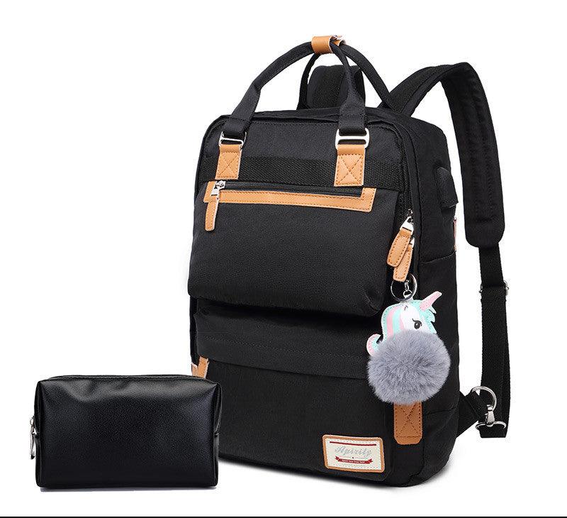 Sac à dos noir élégant avec porte-clés peluche, détails en cuir marron, poches zippées, accompagné d'une trousse noire. Accessoire mode pratique.