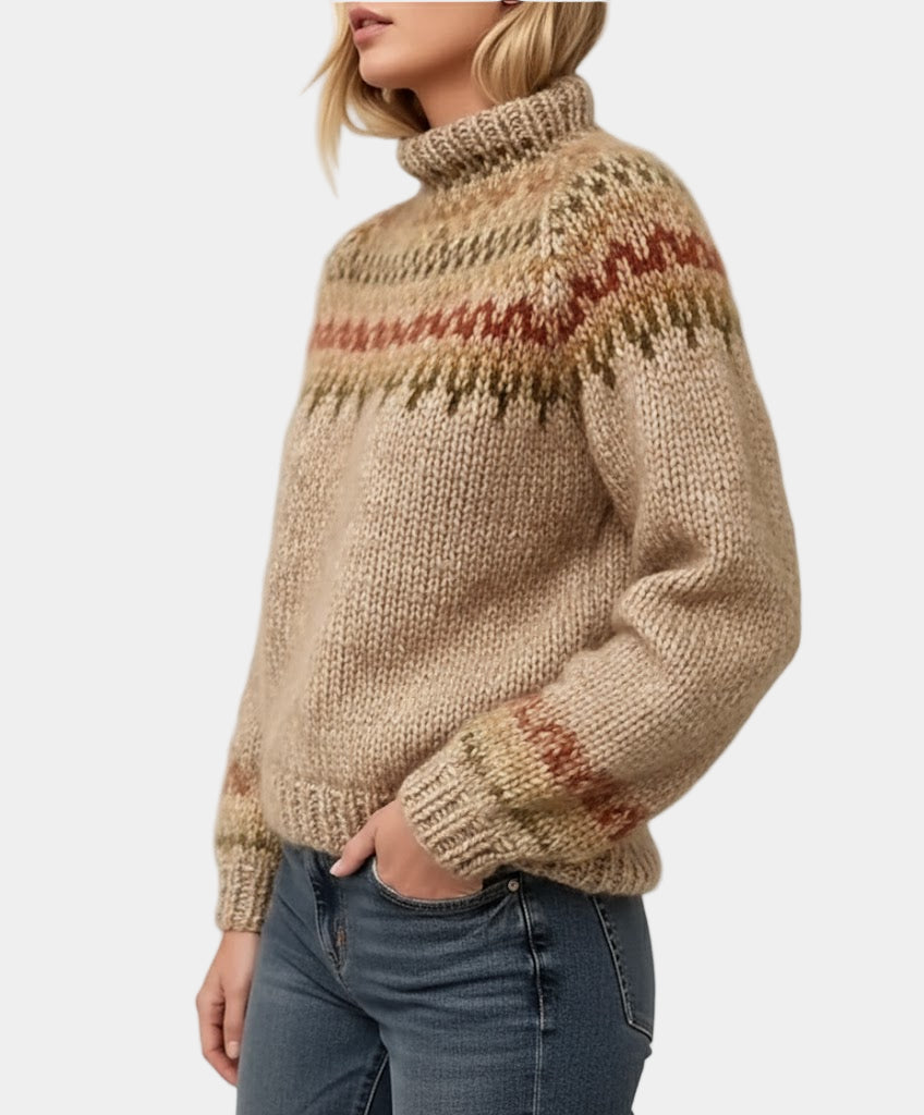 Femme portant un pull en laine beige à col roulé avec motifs nordiques, manches longues, associé à un jean bleu. Mode hiver, style scandinave.