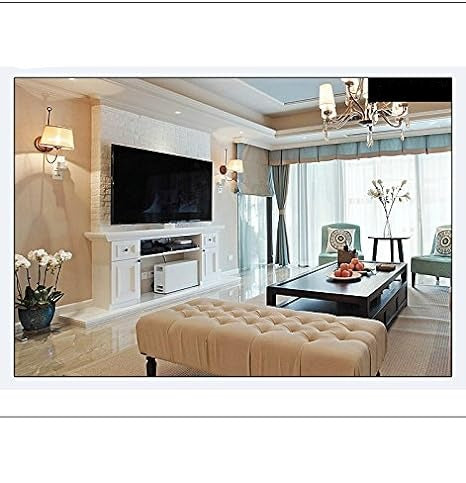 Salon moderne avec canapé beige, table basse en bois, grand téléviseur mural, lustre élégant et grandes fenêtres laissant entrer la lumière naturelle.