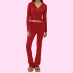 Femme en ensemble de survêtement rouge, veste zippée et pantalon, sur fond rose. Mode décontractée, tenue confortable, style moderne.