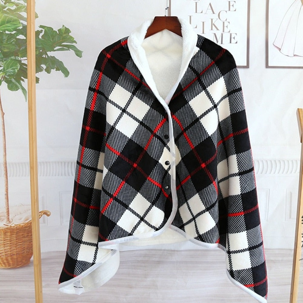 Cape en laine à carreaux noirs, blancs et rouges, suspendue sur un cintre en bois, avec intérieur en fausse fourrure blanche, style élégant et moderne.