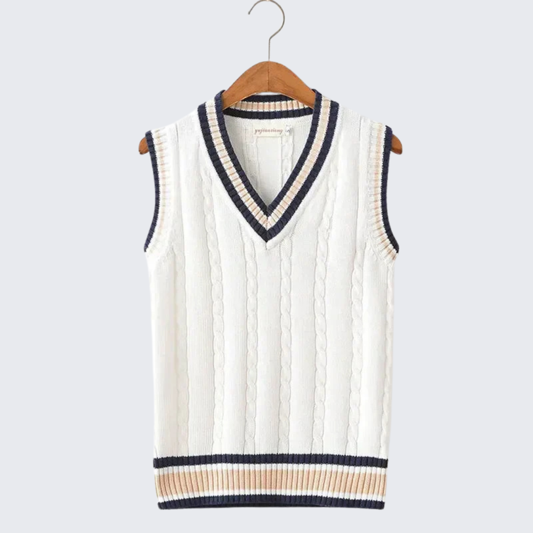 Gilet sans manches en tricot blanc avec col en V, bordures rayées bleu marine et beige, suspendu sur un cintre en bois. Mode élégante et tendance.