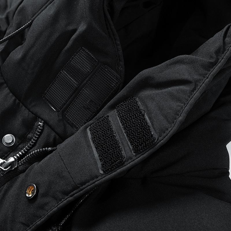 Veste noire avec capuche, fermetures à scratch et boutons-pression, tissu imperméable. Mode hiver, vêtements chauds, style urbain.