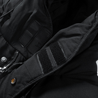 Veste noire avec capuche, fermetures à scratch et boutons-pression, tissu imperméable. Mode hiver, vêtements chauds, style urbain.